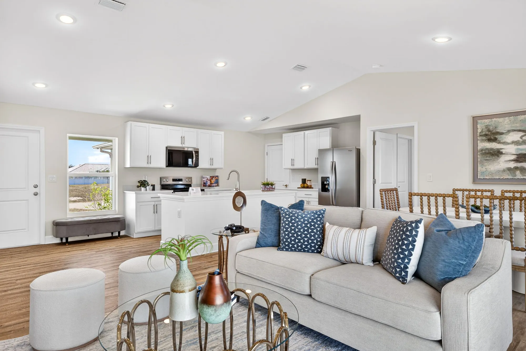 Open living room with sofa and white kitchen cabinets
