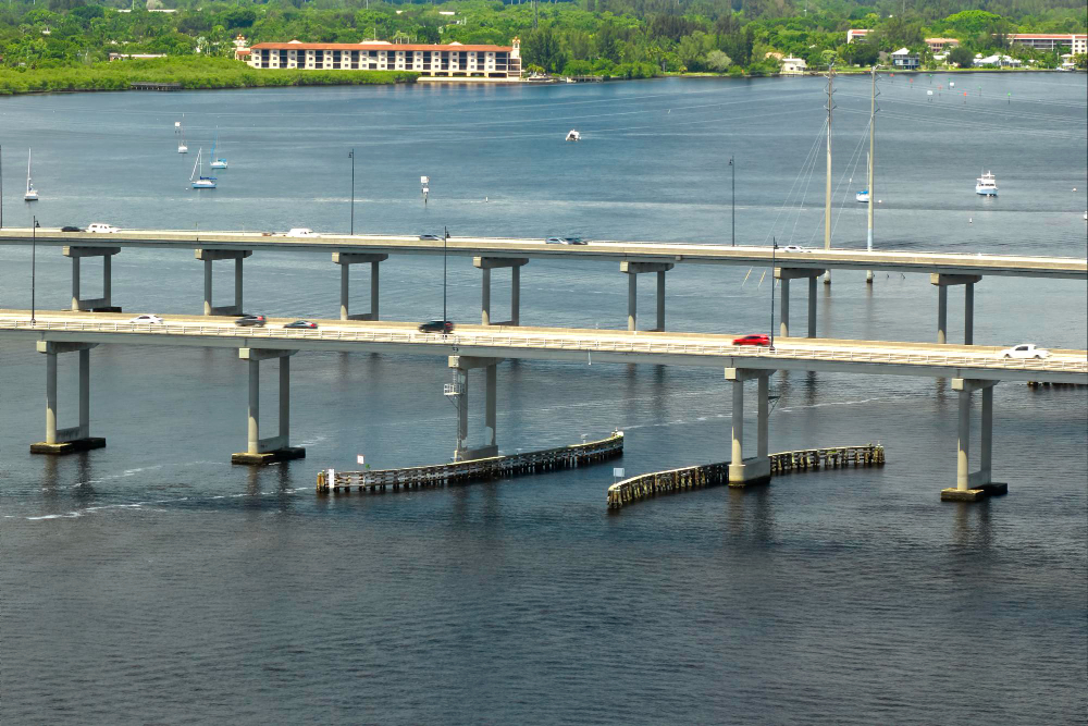 Bridge over water with cars and sailboats nearby