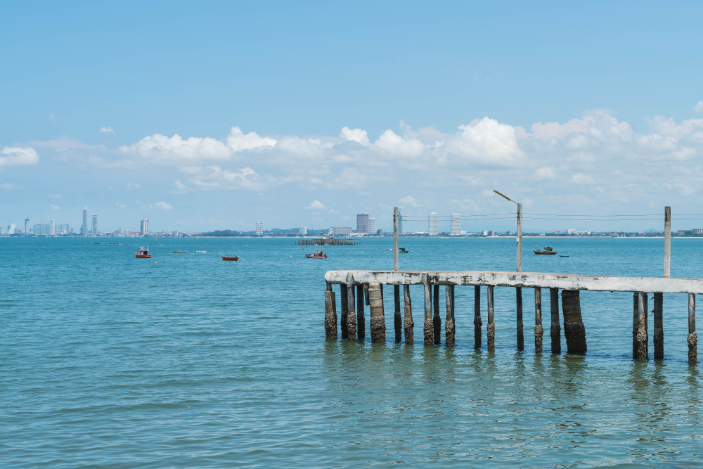 Pier over calm blue water with distant boats