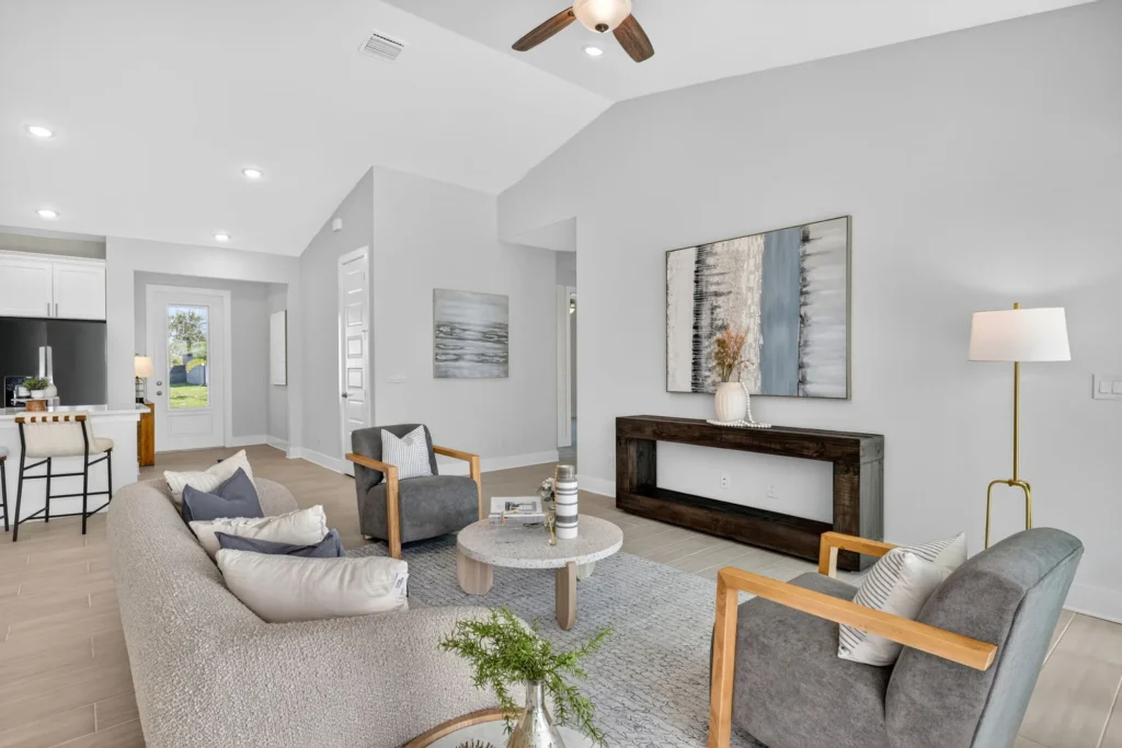 Modern open living room with sofa, chairs, coffee table.