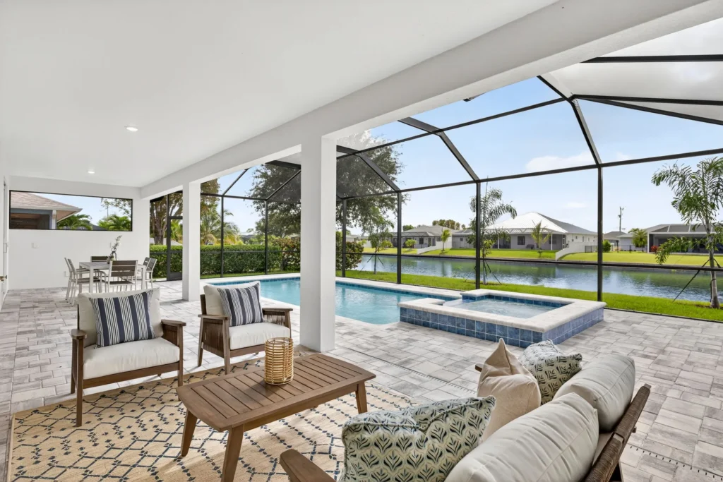 Covered patio seating beside screened pool and spa