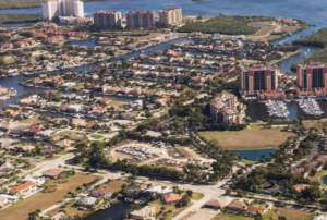 Aerial view of waterfront neighborhood with canals, marina, high-rises.
