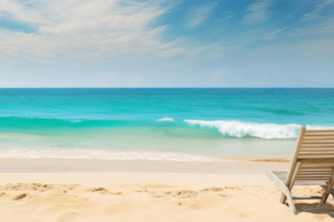 Beach with turquoise ocean waves and empty lounge chair