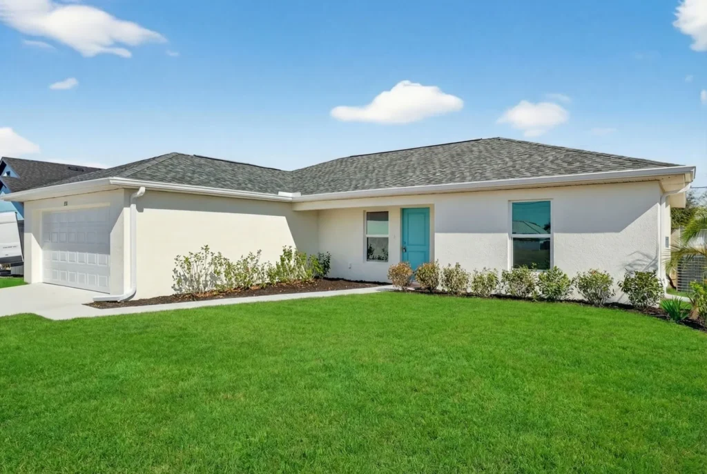 Single-story white house with garage and turquoise front door.