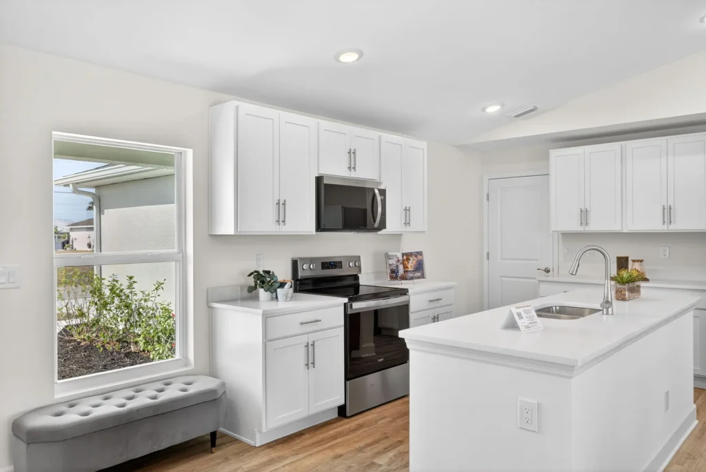Bright white kitchen with island sink and stainless appliances