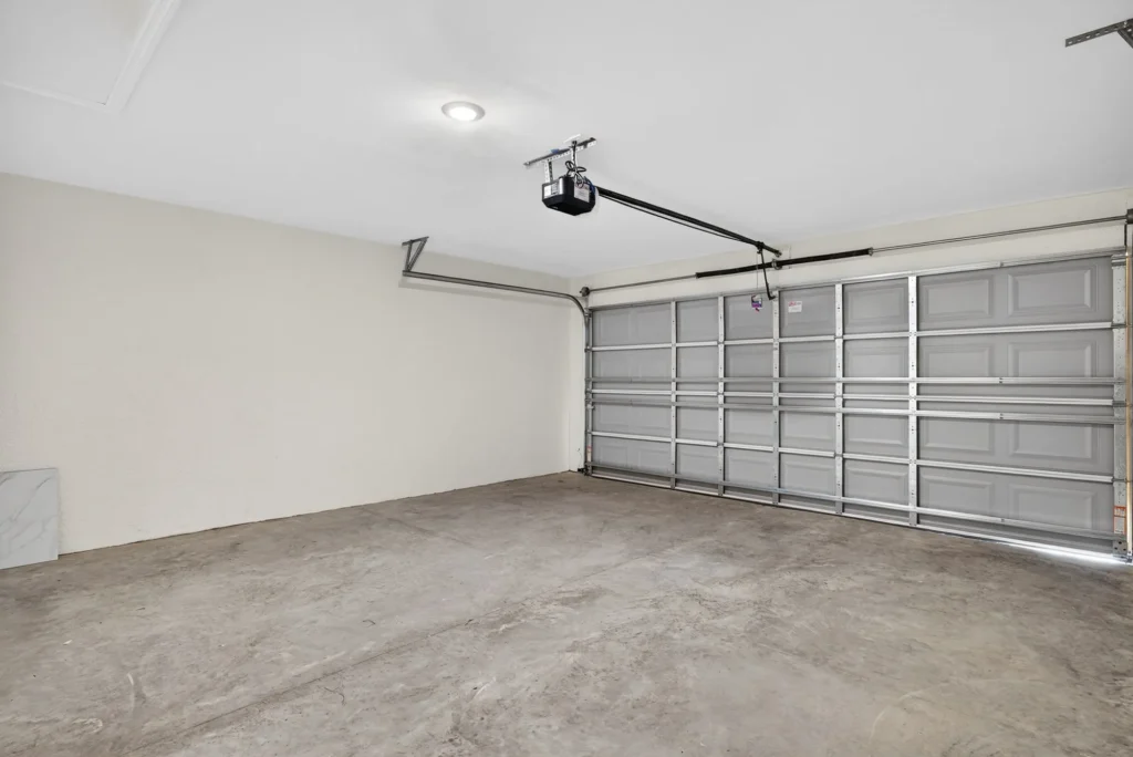 Empty garage with concrete floor and overhead door opener