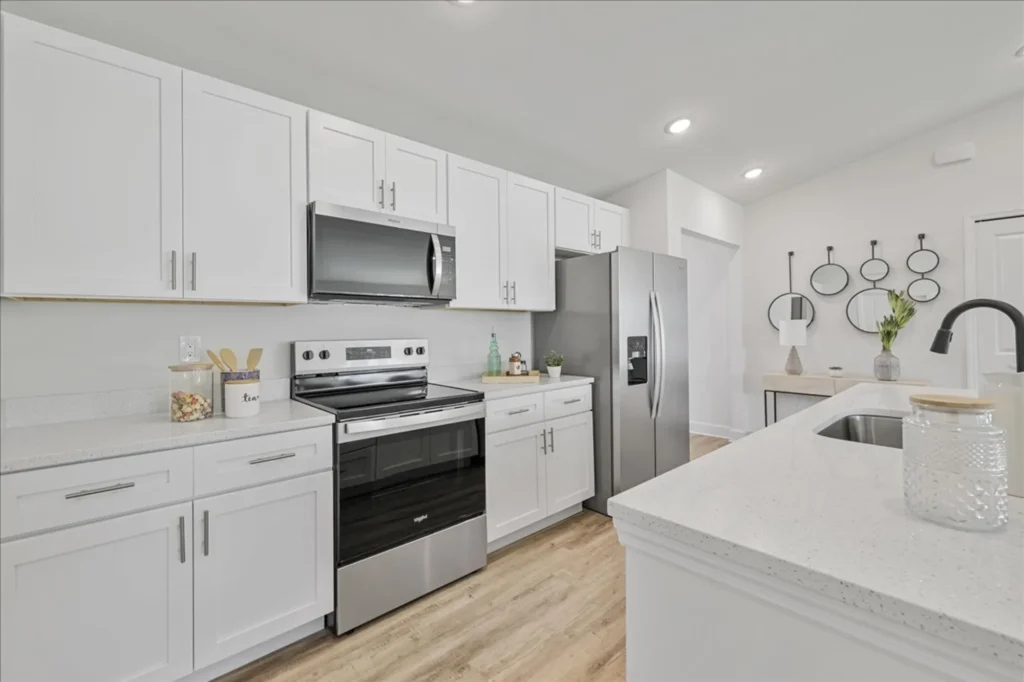 White kitchen with stainless appliances and island sink