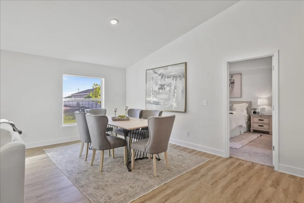 Dining table with six chairs near window and bedroom doorway.