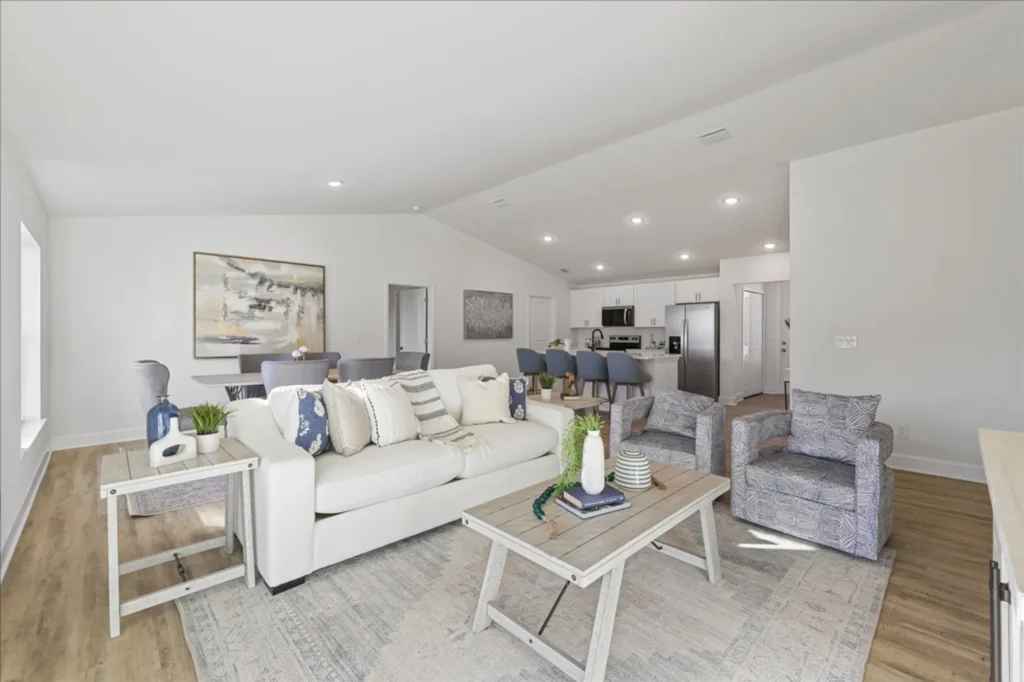 Open living room with sofa, chairs, and kitchen view