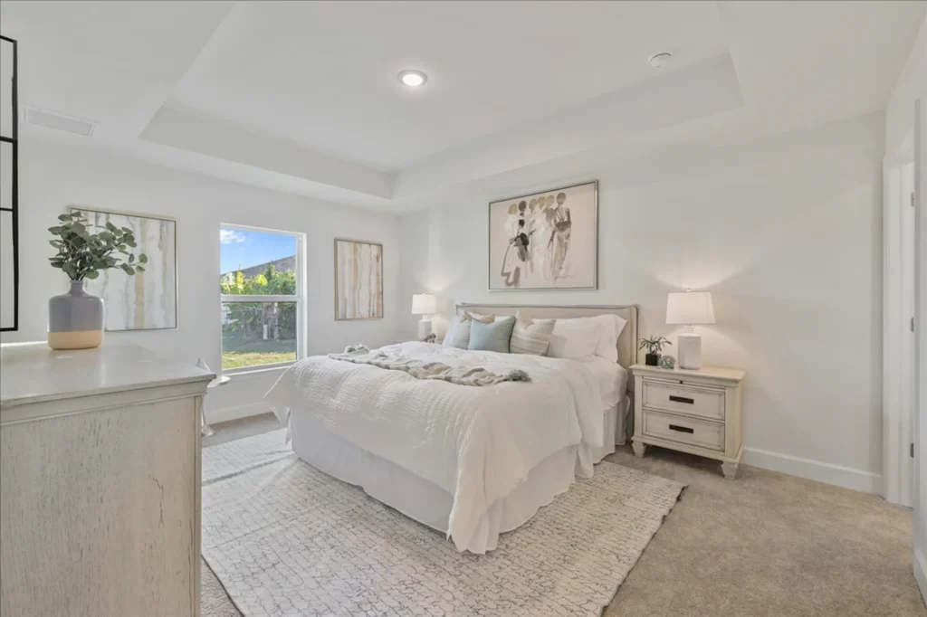 Bright bedroom with white bed, nightstands, and window