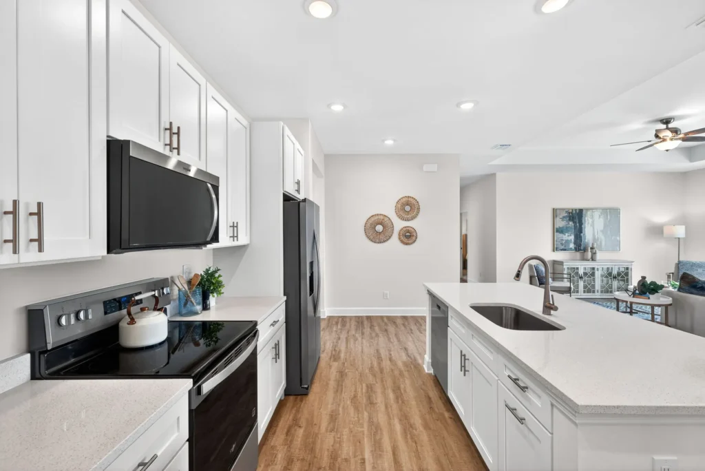 Modern white kitchen with black appliances and large island