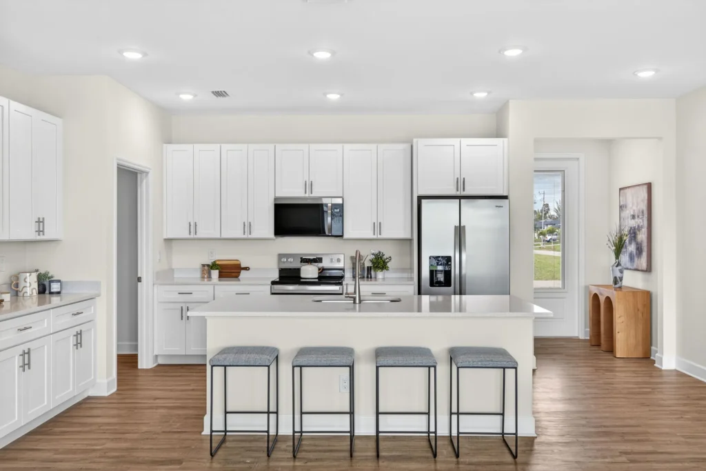 Modern white kitchen with island, stools, and stainless appliances
