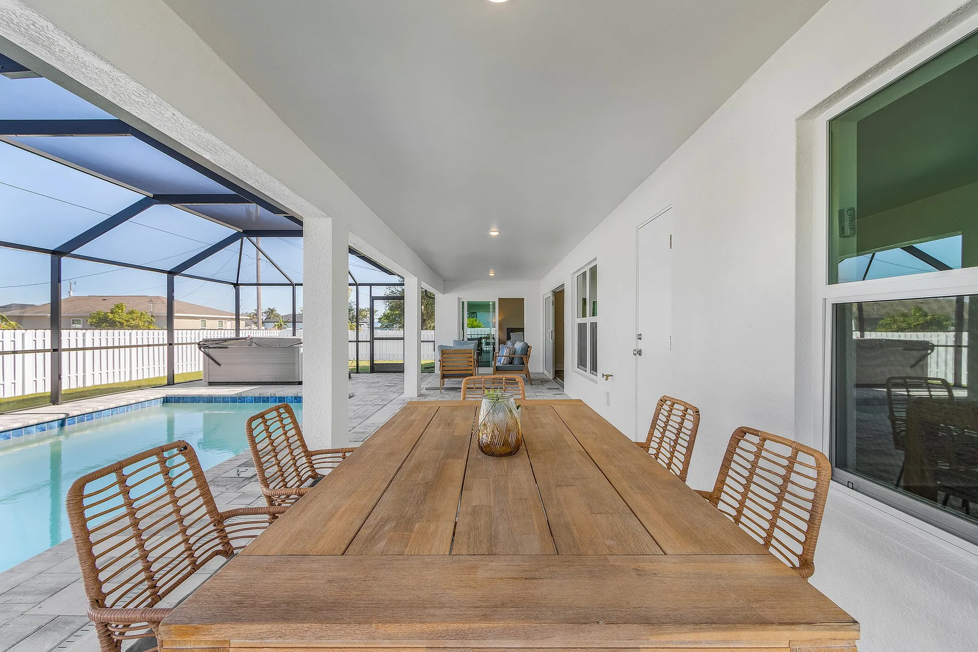 Covered patio dining table beside screened-in pool