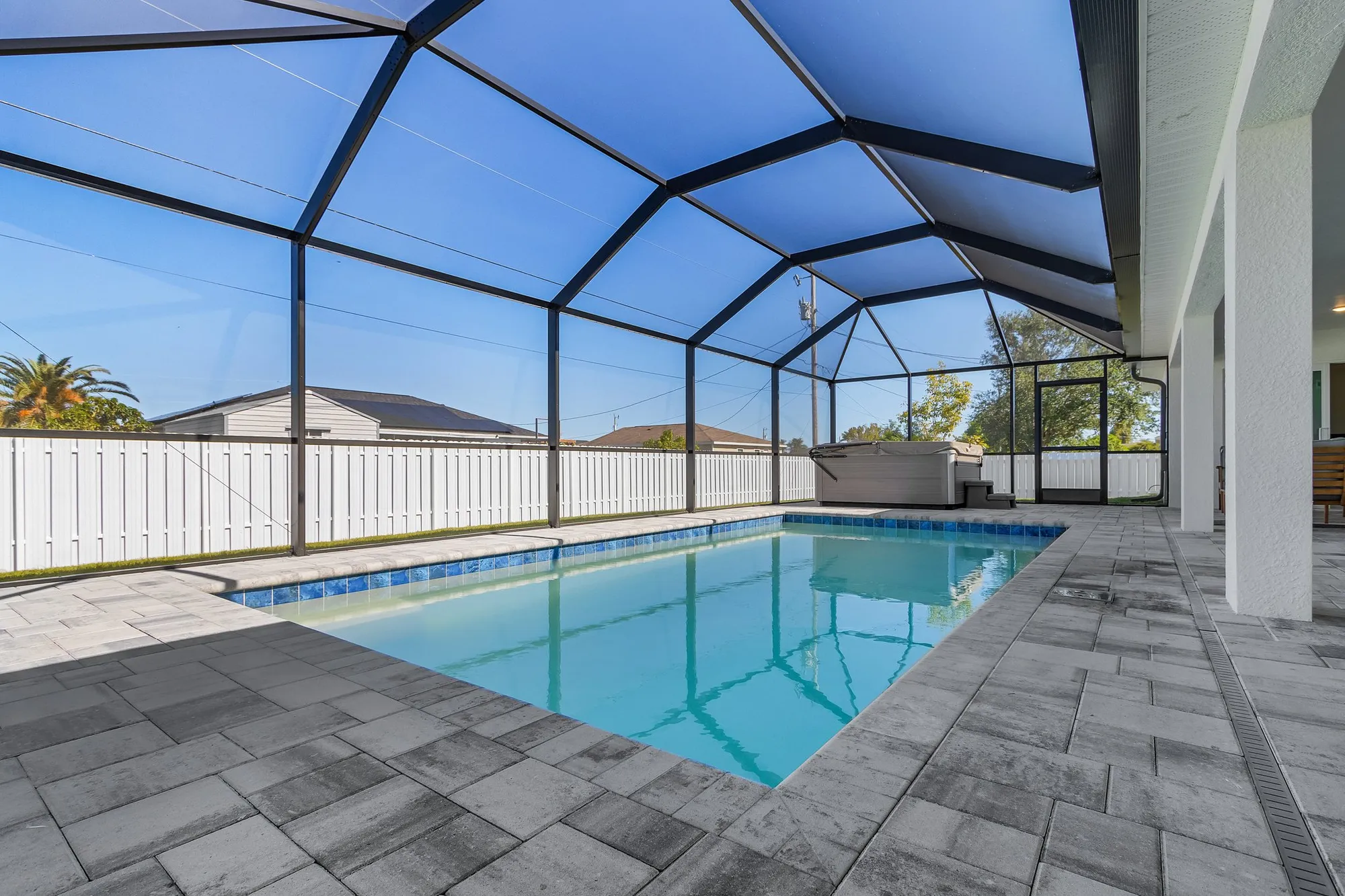 Screened backyard pool with paver patio and spa