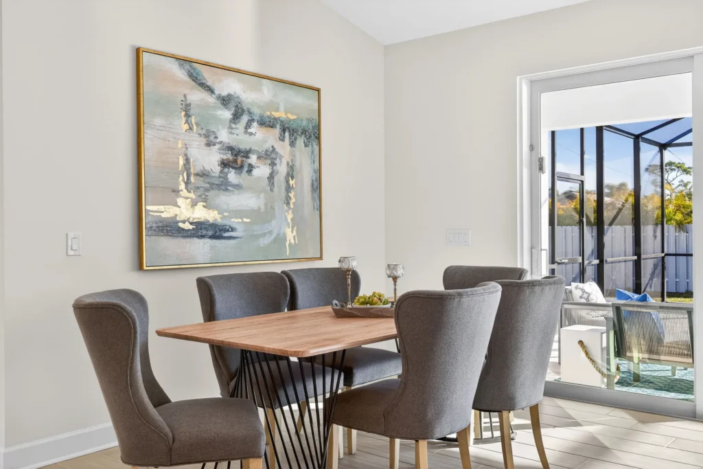 Dining table with gray chairs beside sliding glass patio door