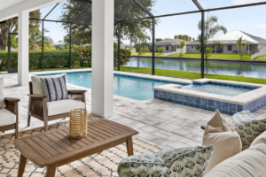 Covered patio with seating, screened pool and spa view
