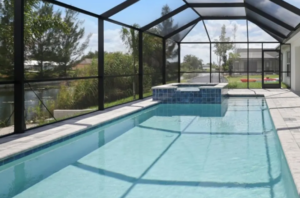 Screened lanai pool with raised spa and water view