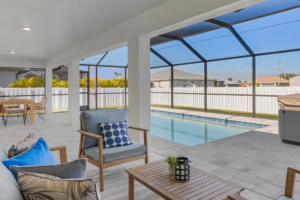 Covered patio seating beside screened-in backyard pool
