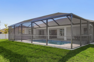 Screened pool enclosure behind single story home