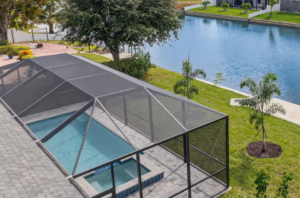 Screened pool enclosure beside canal and grassy yard