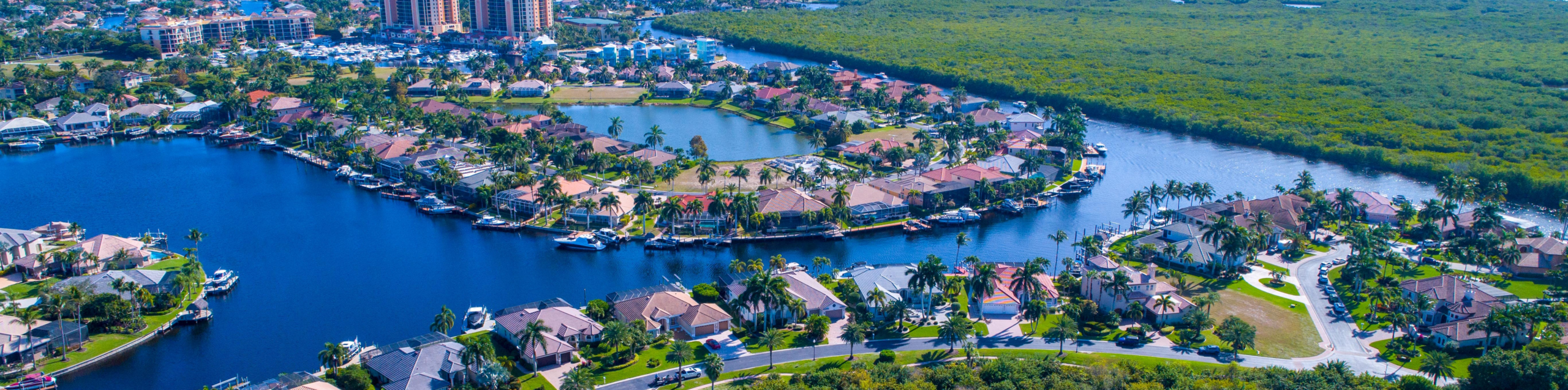 Aerial view of waterfront homes along canal with boats