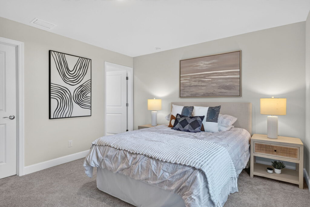 Modern bedroom with bed, two lamps, and wall art