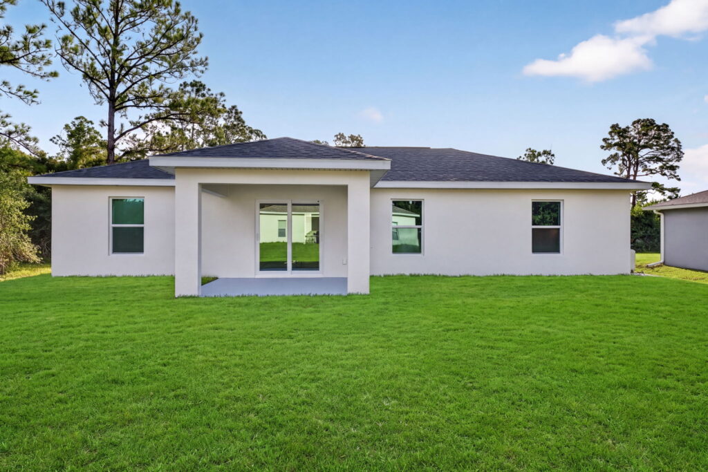 Backyard view of single story home with covered patio