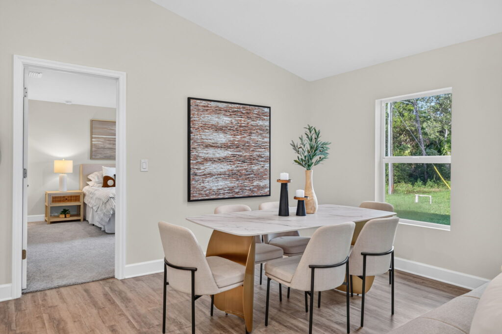 Modern dining table and chairs beside window and bedroom doorway
