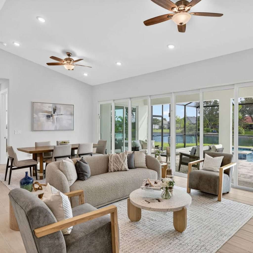 Open living room with sliders to the lanai and pool in a SunLife Coral Haven